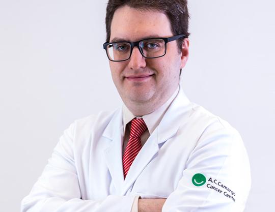 Doutor Daniel Garcia, branco, 35 anos, cabelo castanho curto, óculos e jaleco
