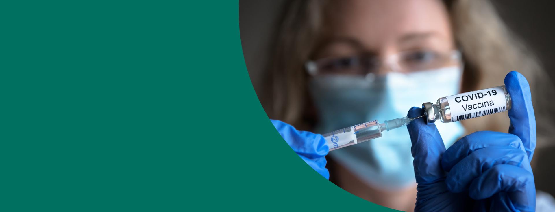 Mulher loira com máscara segura uma vacina