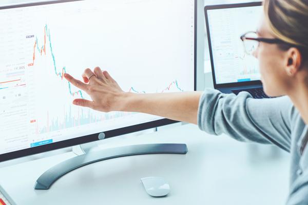 Uma mulher apontando para uma tela de computador
