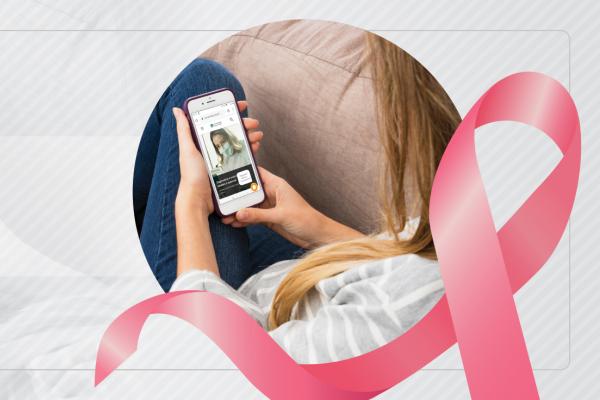 Imagem de uma mulher olhando o celular com um laço rosa da campanha Outubro Rosa