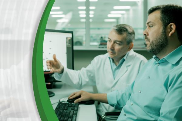 Doutor Israel e Doutor Helano, brancos, conversam diante do computador