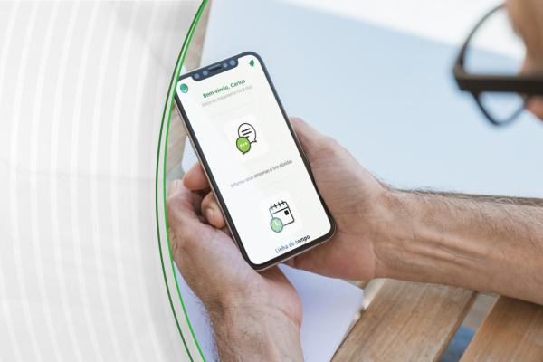 Homem com celular na mão, olhando a tela do aplicativo de monitoramento remoto