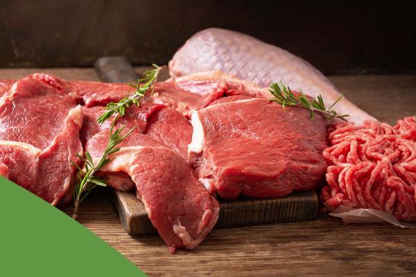 Carne vermelha crua e temperada sobre uma mesa de madeira
