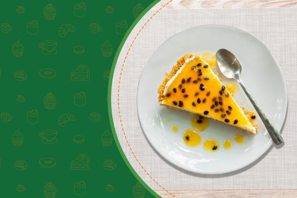 A imagem mostra uma fatia de torta de maracujá em um prato branco