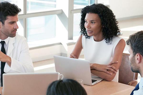Pessoas reunidas em uma mesa no trabalho conversando