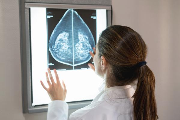 Mulher olhando a mamografia de uma paciente