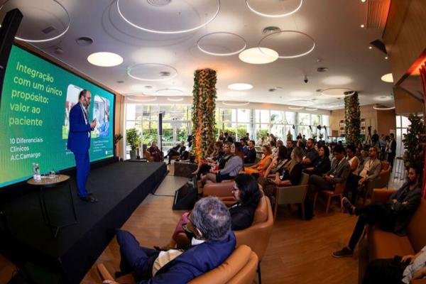 Evento em que várias pessoas estão sentadas assistindo um diretor falar