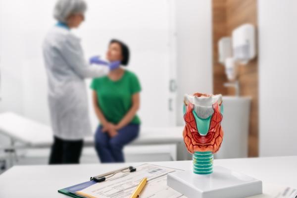 Médica examinando o pescoço de uma paciente