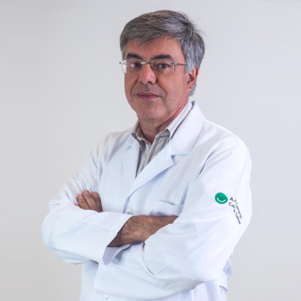 Doutor João Duprat, branco, cabelos grisalhos, braços cruzados e jaleco