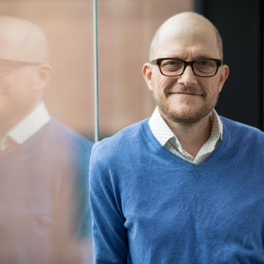 Dr. Steven Pergam, careca, loiro, de óculos e blusa de lã azul