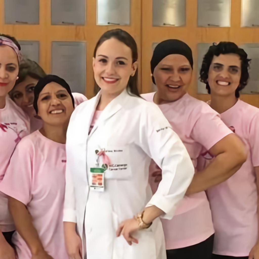 Um grupo de mulheres vestido de rosa e uma médica com jaleco branco