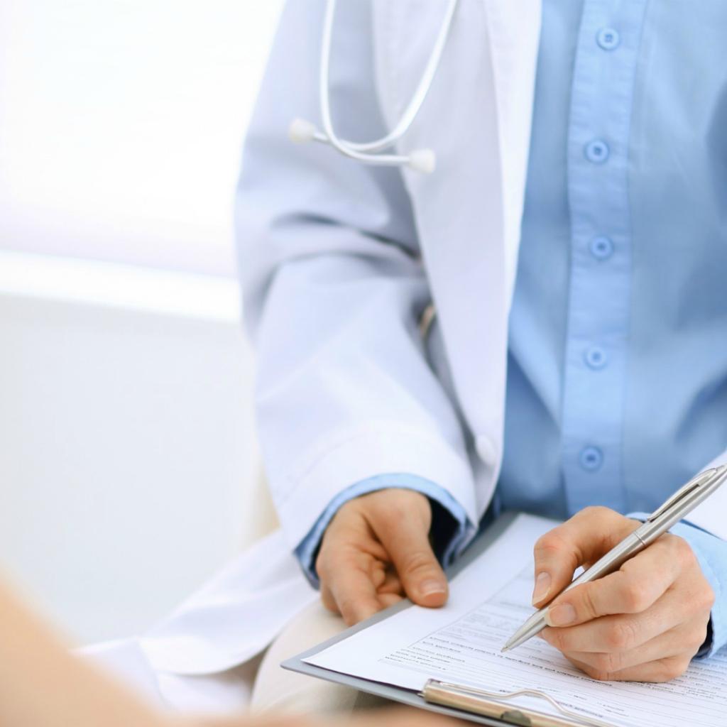 Médico conversa com paciente e preenche formulário