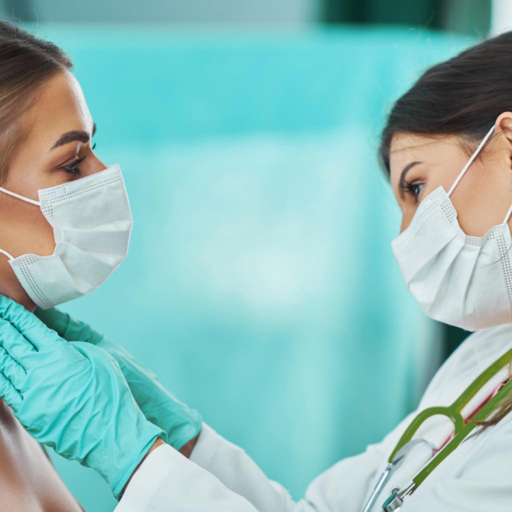 Médica examina pescoço de paciente