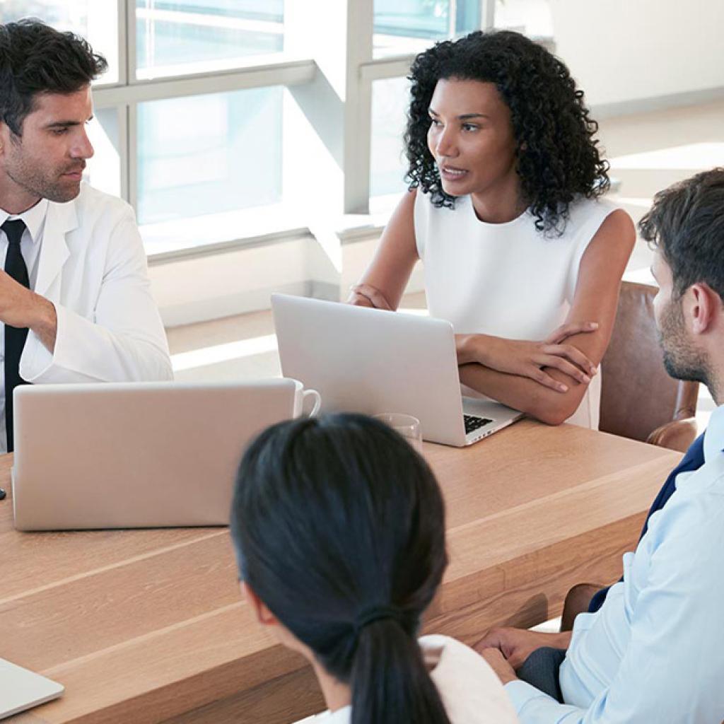 Pessoas reunidas em uma mesa no trabalho conversando
