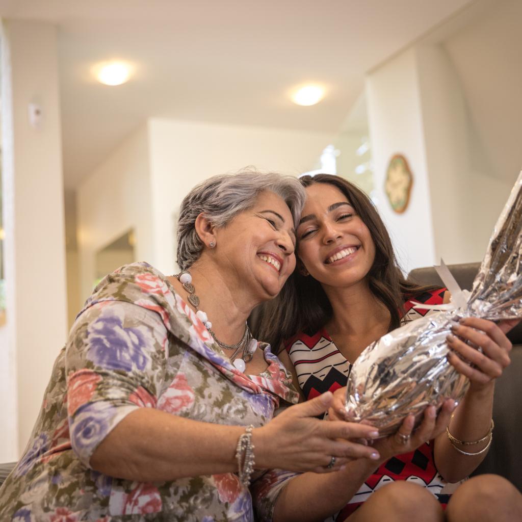 Mulher mais velha e uma mais nova entregando um ovo de páscoa