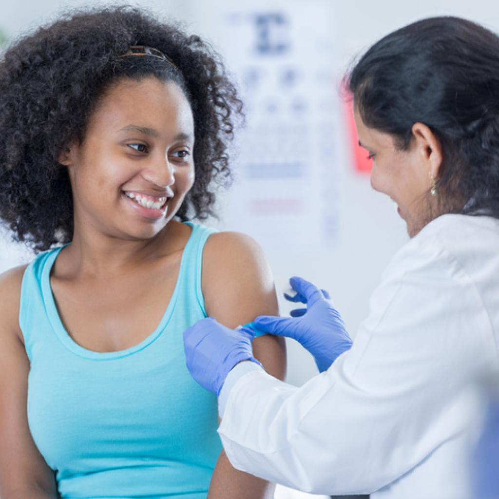Menina adolescente tomando vacina