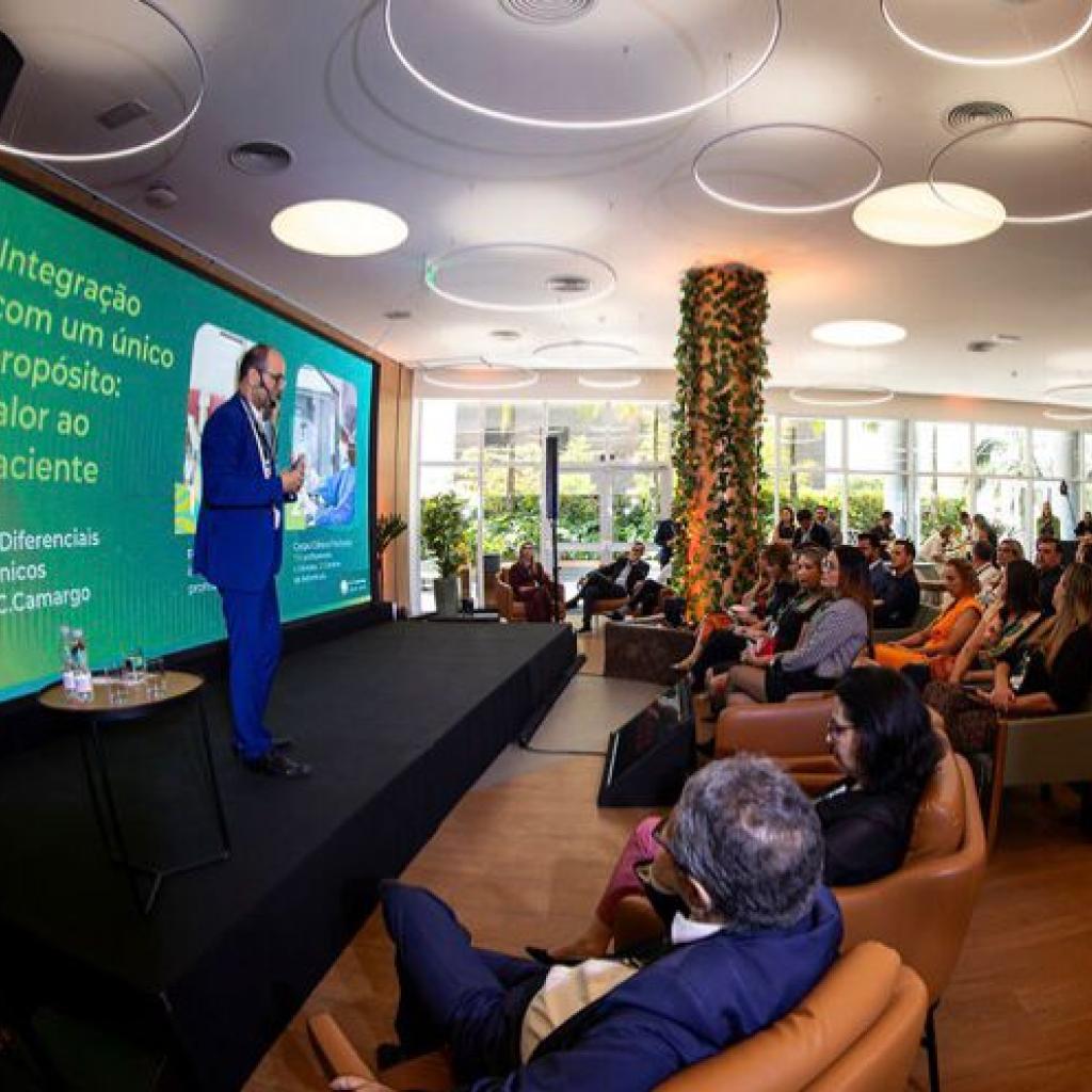 Evento em que várias pessoas estão sentadas assistindo um diretor falar
