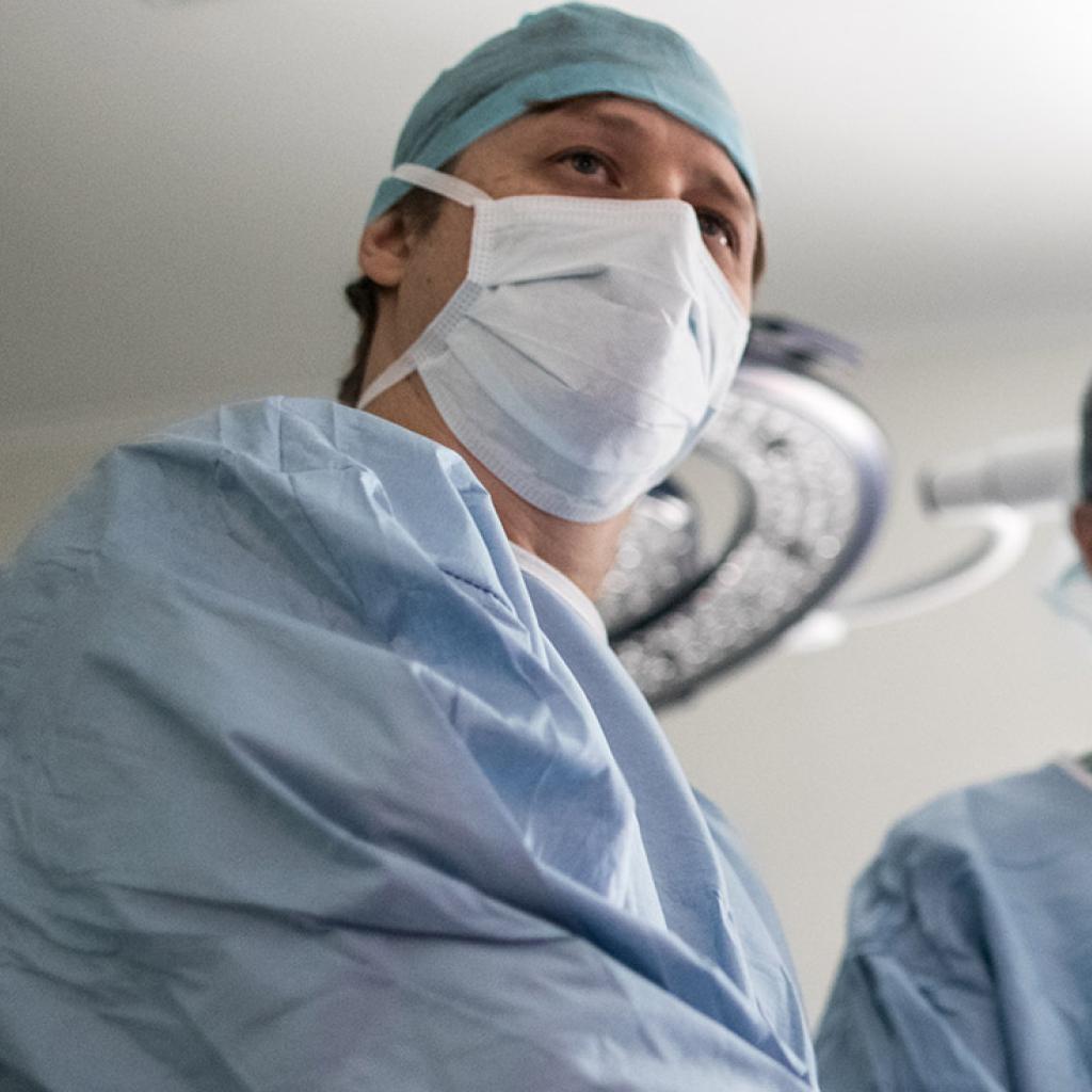 Três cirurgiões médicos em uma sala cirúrgica