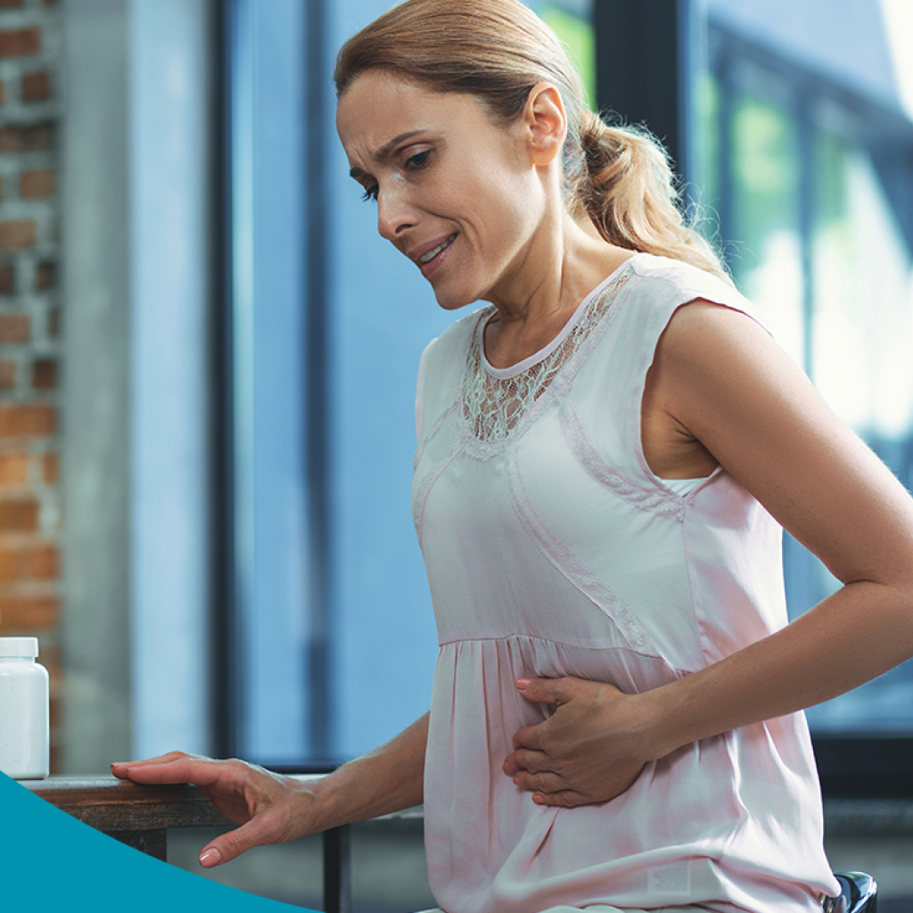 Arte gráfica com fundo azul. Ao lado direito, uma mulher branca loira coloca a mão na região do intestino.